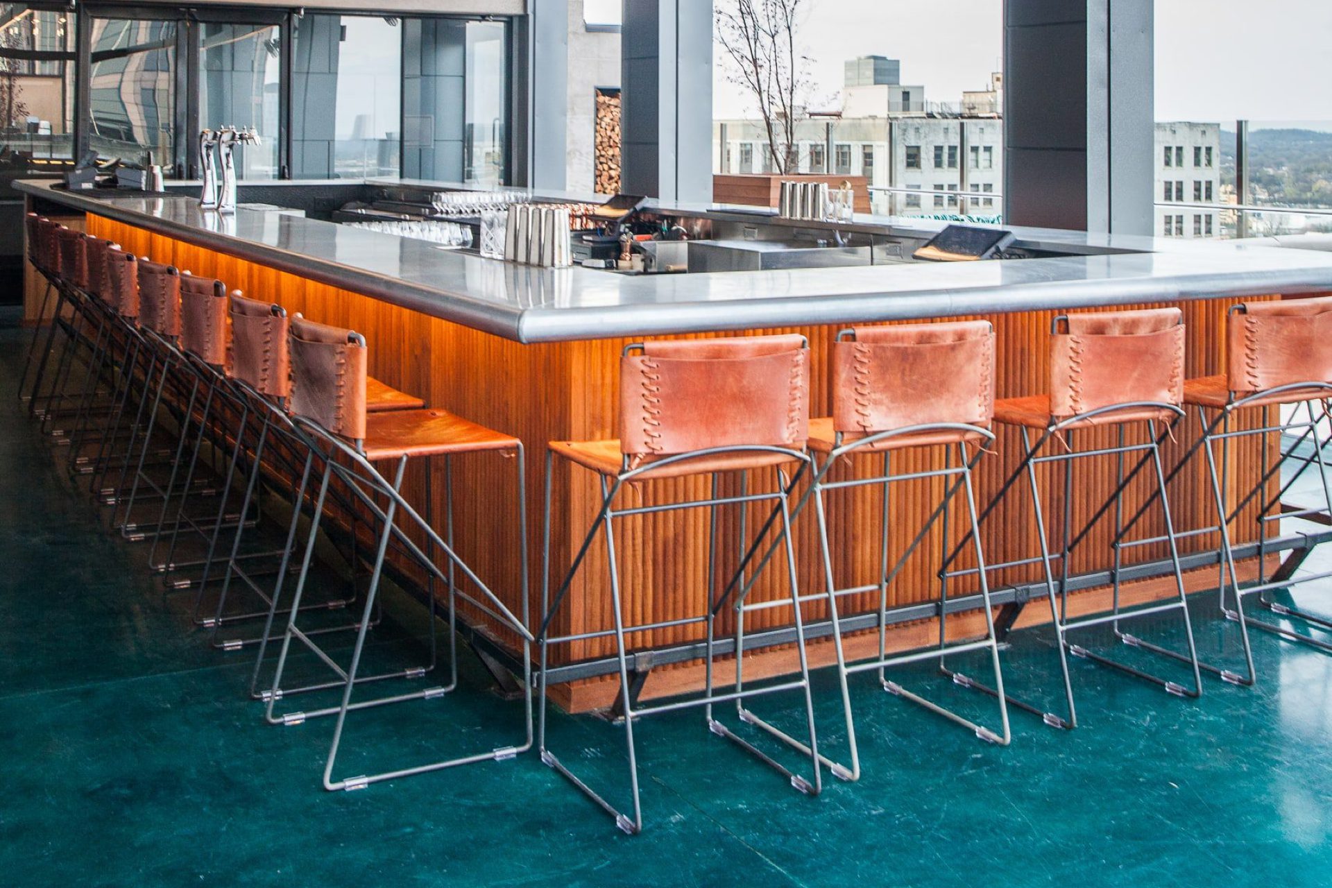 barstools in front of a modern bar that is both inside and outside