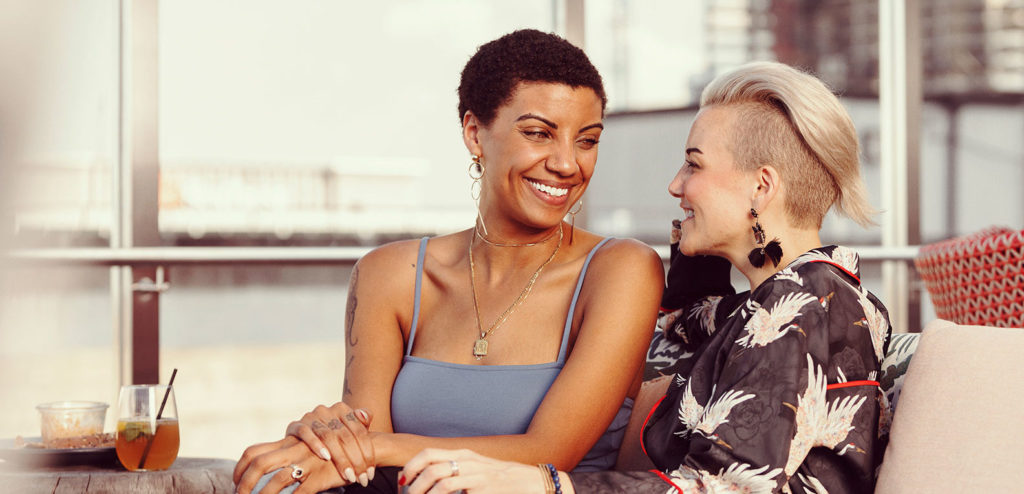 Two women talking on rooftop bar