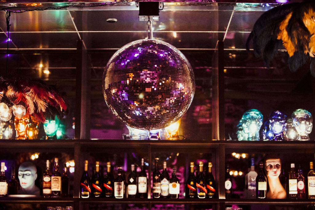 A silver disco ball above a bar