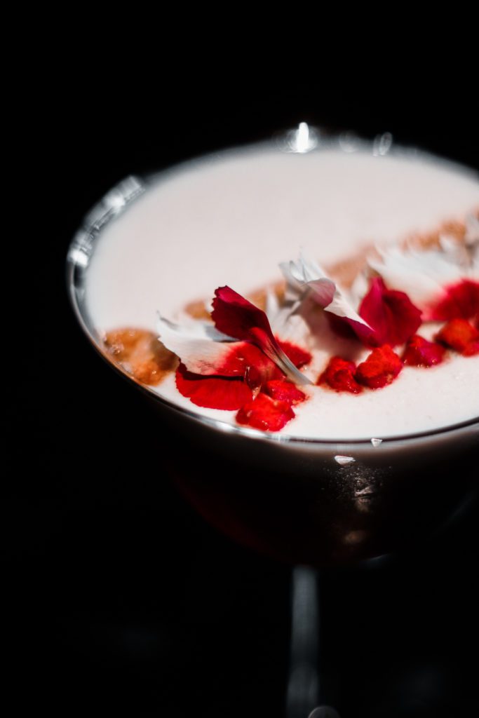 A cocktail with a floral garnish.