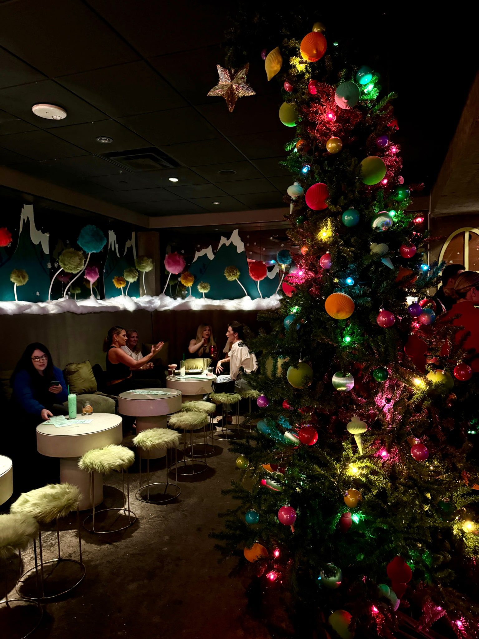 people enjoying themselves in a christmas themed bar setting